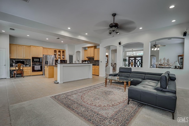 living room featuring light tile patterned floors, decorative columns, and ceiling fan