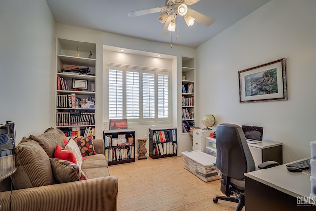 office space featuring built in shelves, light hardwood / wood-style floors, and ceiling fan