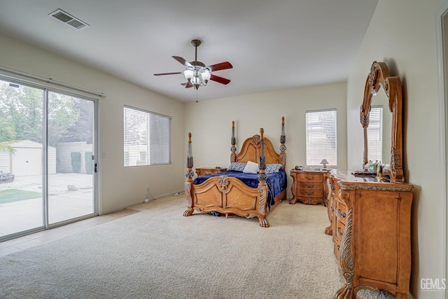 bedroom with access to exterior, multiple windows, light colored carpet, and ceiling fan