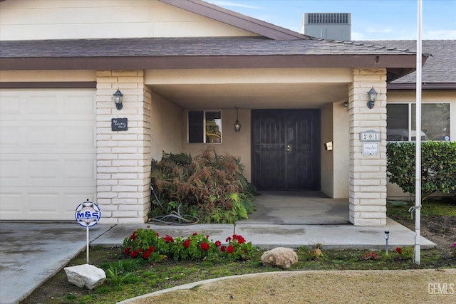 property entrance featuring cooling unit and a garage