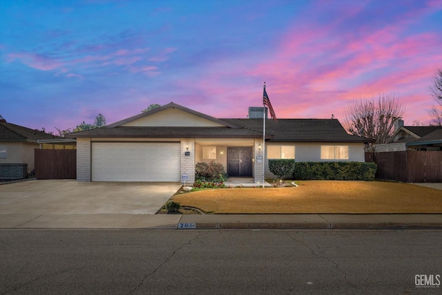 ranch-style house with a garage and a yard