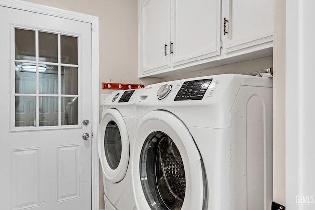 laundry room featuring washer and clothes dryer and cabinets