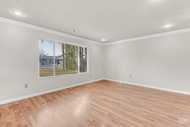 spare room featuring crown molding, light hardwood / wood-style floors, and a textured ceiling