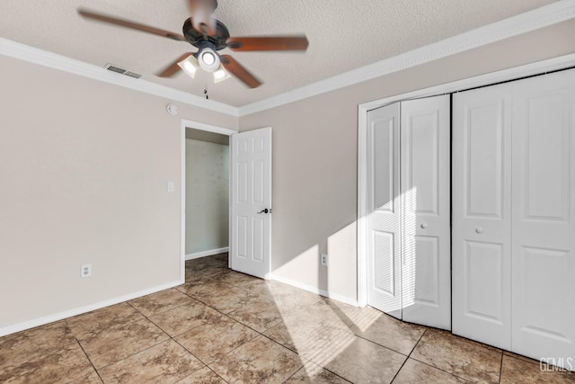 unfurnished bedroom with light tile patterned flooring, ceiling fan, crown molding, a textured ceiling, and a closet