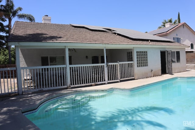 5808 Greenhorn Mountain Ct, Bakersfield, CA 93313 - rear view of house featuring solar panels, a chimney, and stucco siding