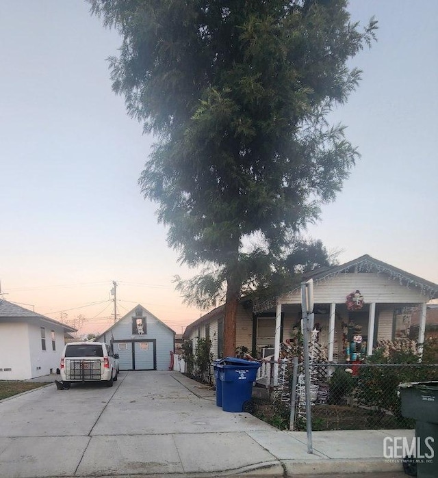 view of front of house featuring a porch, a garage, and an outbuilding