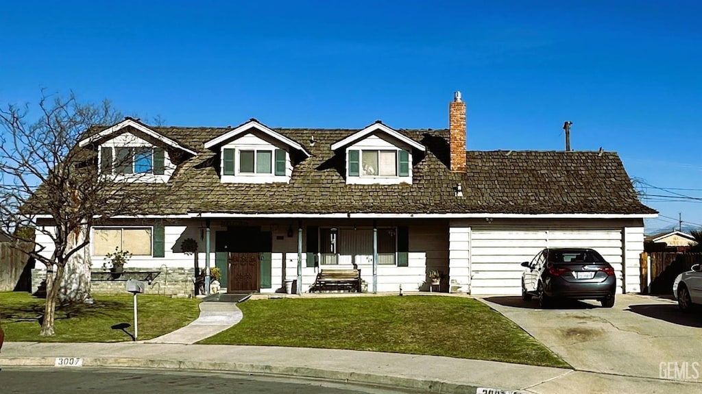 view of front facade featuring driveway, a chimney, and a front lawn