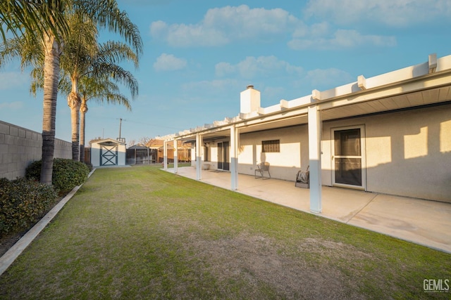 view of yard featuring a storage unit and a patio