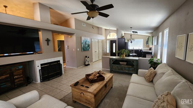 3808 Mariana Way, Bakersfield, CA 93311 - living area featuring vaulted ceiling, a ceiling fan, light tile patterned floors, a tiled fireplace, and a chandelier
