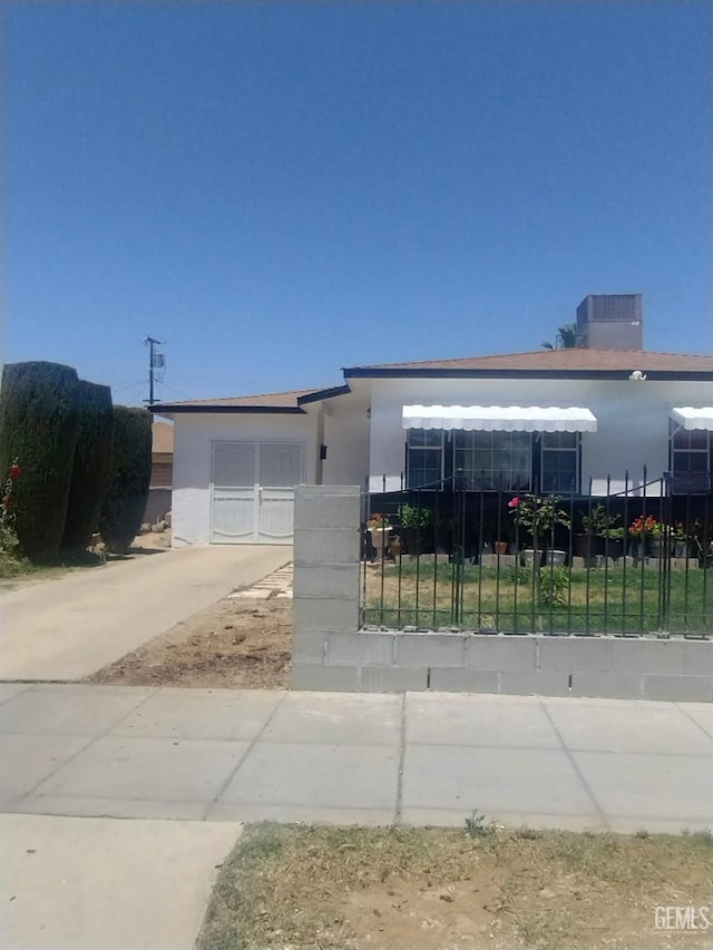 1222 E 18 Th St, Bakersfield, CA 94405 - view of front facade featuring a fenced front yard, stucco siding, and driveway