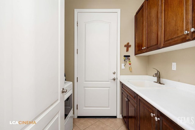6006 Colchester Pl, Bakersfield, CA 93306 - washroom with laundry area, a sink, and light tile patterned floors