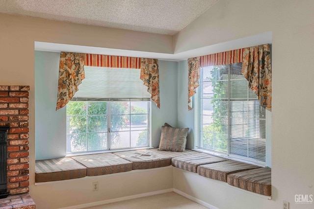 unfurnished room featuring a wood stove, a textured ceiling, and lofted ceiling