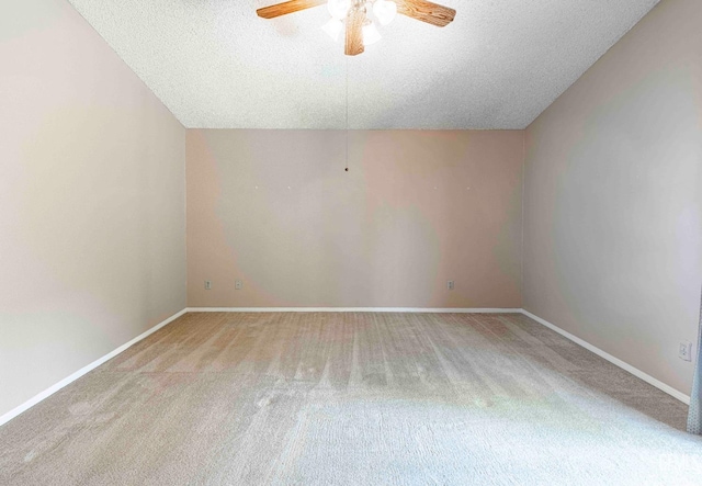 spare room featuring baseboards, a ceiling fan, carpet, and a textured ceiling