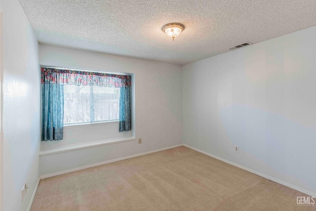 unfurnished room featuring visible vents, baseboards, carpet floors, and a textured ceiling