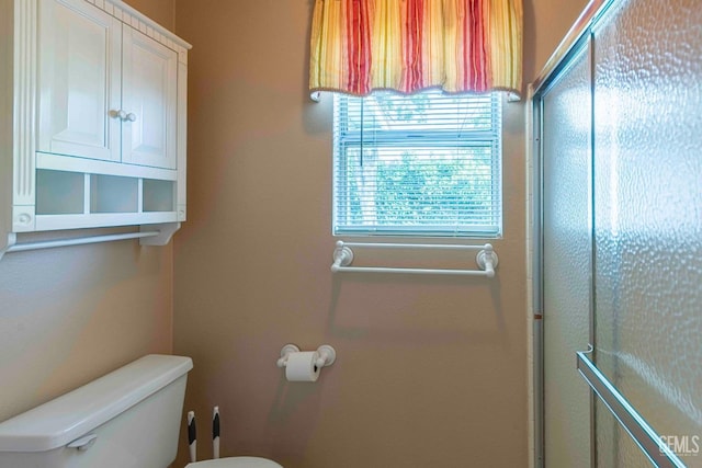 full bathroom with a shower with door and toilet