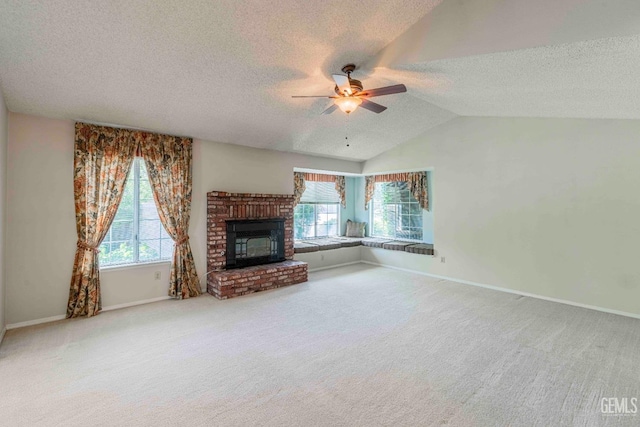 unfurnished living room featuring ceiling fan, a fireplace, carpet, a textured ceiling, and lofted ceiling