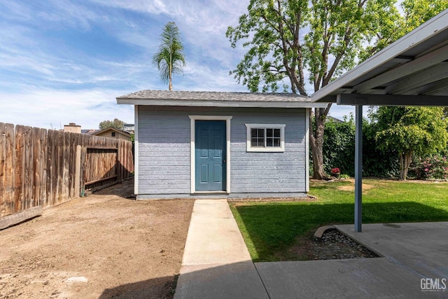 view of outdoor structure with a fenced backyard and an outbuilding