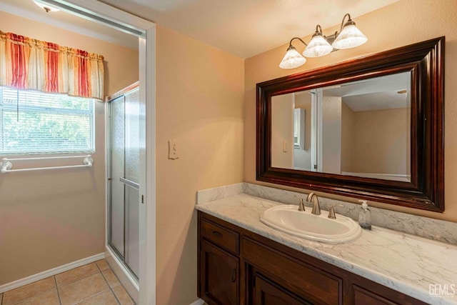 full bathroom with a shower stall, vanity, baseboards, and tile patterned flooring