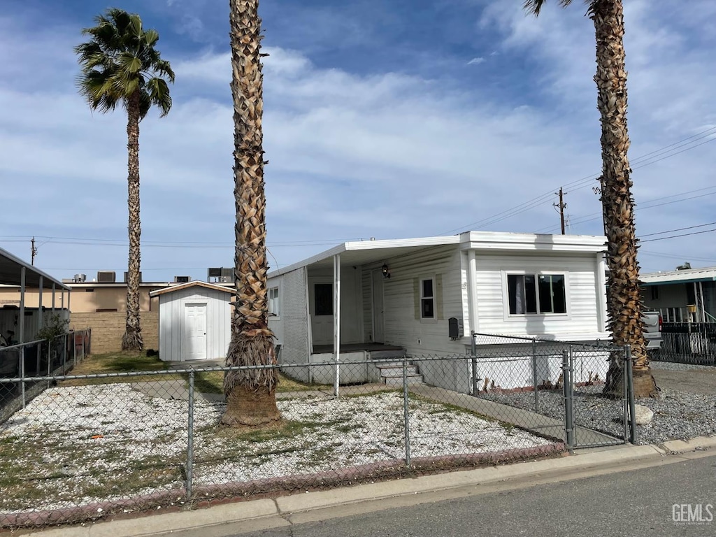4401 Hughes Ln Unit 116, Bakersfield, CA 93304 - manufactured / mobile home featuring a fenced front yard, a carport, and a storage unit