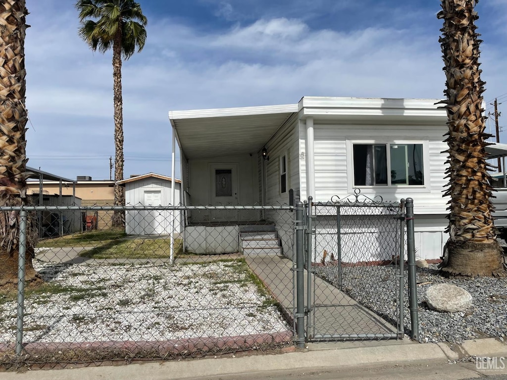 4401 Hughes Ln Unit 116, Bakersfield, CA 93304 - manufactured / mobile home featuring a gate, an attached carport, and a fenced front yard