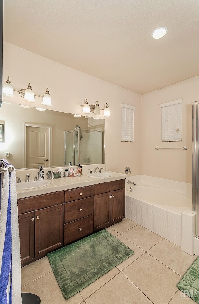 full bathroom featuring double vanity, a garden tub, a sink, and tile patterned floors