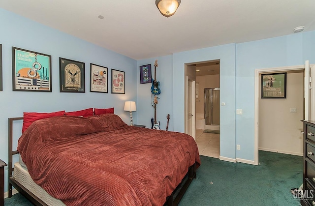 bedroom with dark tile patterned floors, dark carpet, ensuite bath, and baseboards