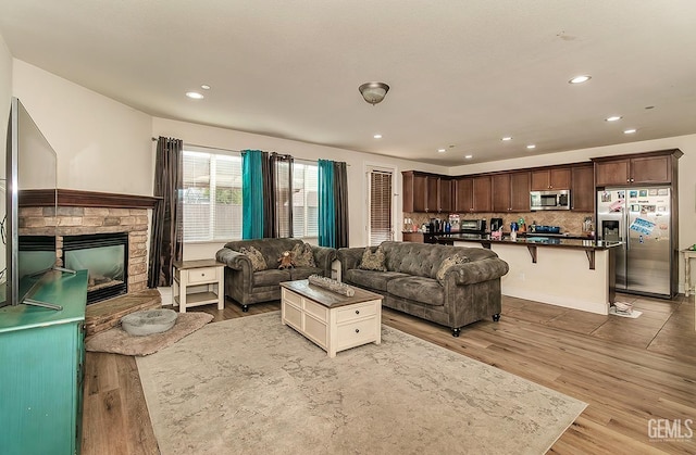 living area with a fireplace, wood finished floors, and recessed lighting