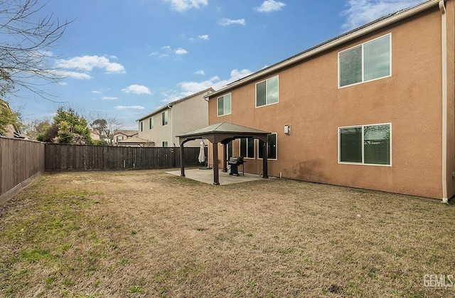 back of house featuring a gazebo, a yard, a patio, and a fenced backyard