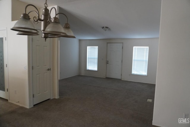 carpeted entryway with a notable chandelier and a healthy amount of sunlight