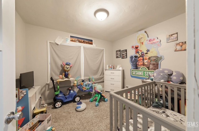 carpeted bedroom with a nursery area