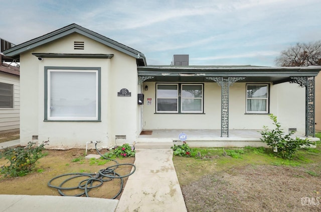 ranch-style home featuring a porch and stucco siding