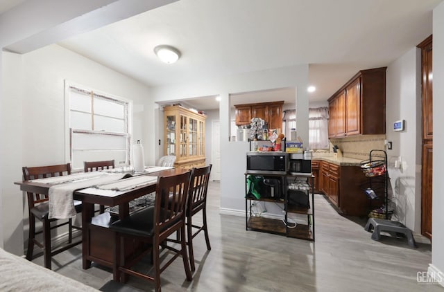 dining area featuring light wood-style flooring and baseboards