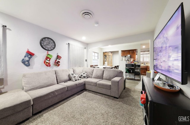 living area with light colored carpet and visible vents