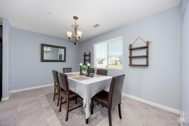 dining room featuring a chandelier, light tile patterned floors, and baseboards