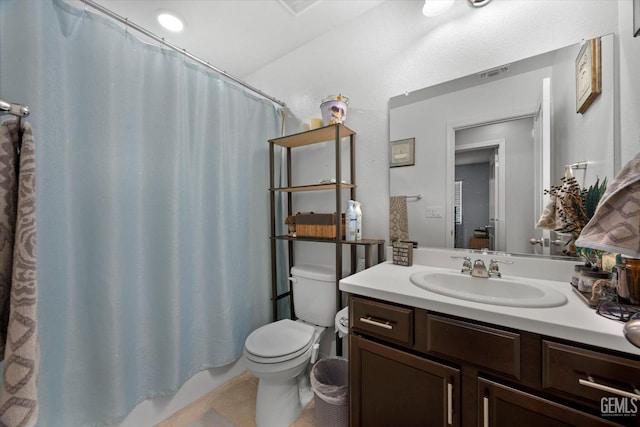 bathroom with toilet, vanity, and tile patterned floors