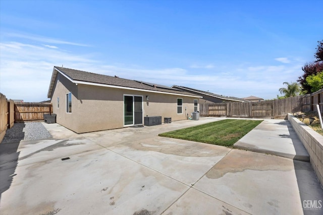 back of house with stucco siding, a patio area, and solar panels