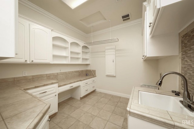 laundry room featuring light tile patterned floors, ornamental molding, and sink