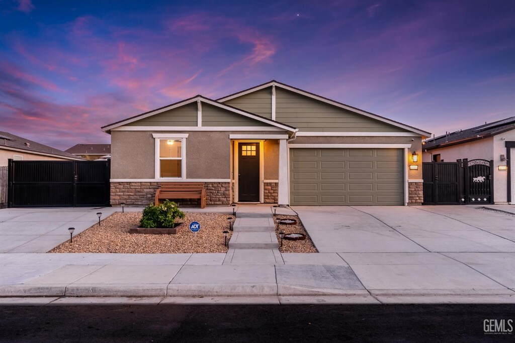 6109 Pareto Pl, Bakersfield, CA 93313 - single story home with stone siding, a gate, concrete driveway, and an attached garage