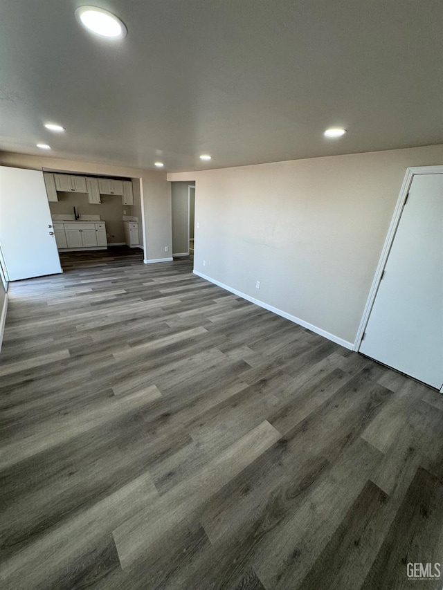 7704 Buena Vista Blvd, Lamont, CA 93241 - unfurnished living room with recessed lighting, baseboards, dark wood finished floors, and a sink