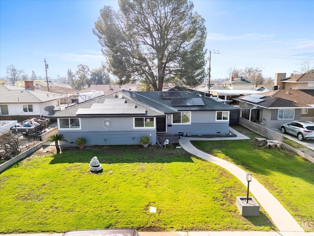 view of front of home featuring a front yard and solar panels