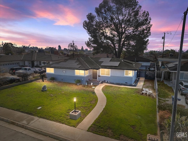 single story home featuring a yard and solar panels