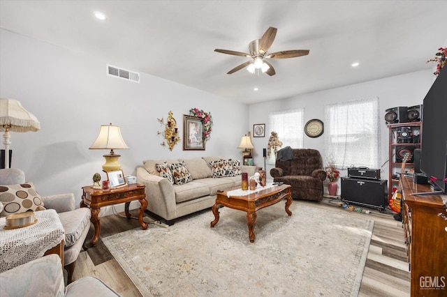 living room featuring ceiling fan and light hardwood / wood-style floors