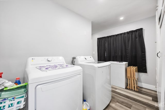 laundry room with wood-type flooring and washer and dryer