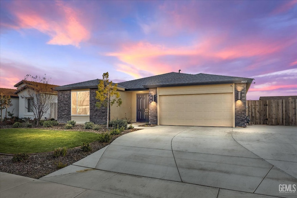 view of front of property featuring a garage and a lawn