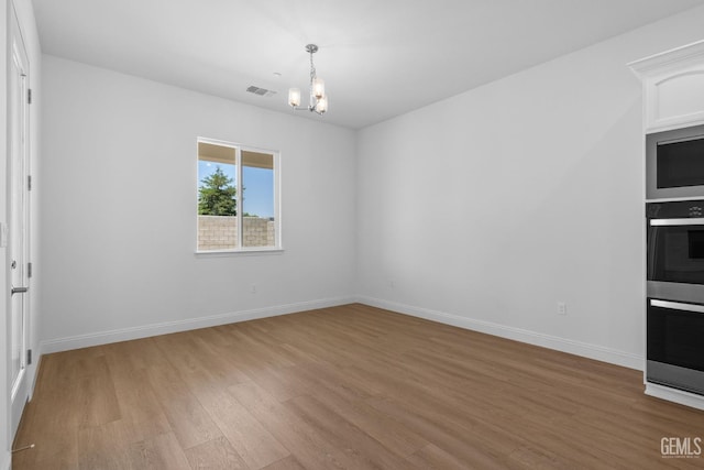 8708 Tamburlane Ct, Bakersfield, CA 93314 - empty room featuring a chandelier and light wood-type flooring
