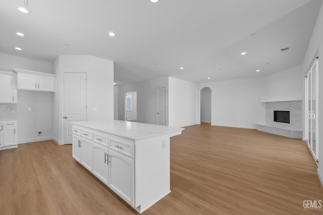 8708 Tamburlane Ct, Bakersfield, CA 93314 - kitchen featuring arched walkways, light wood-style flooring, white cabinetry, recessed lighting, and a center island