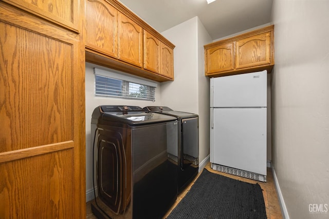 laundry room with washer and dryer, cabinet space, and baseboards