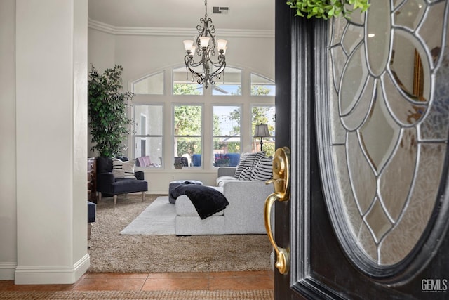 entryway with a chandelier, baseboards, crown molding, tile patterned flooring, and carpet