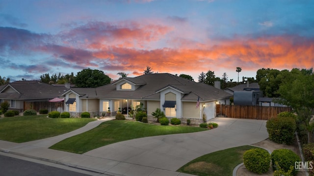 view of front of property featuring driveway, an attached garage, stone siding, and a tile roof