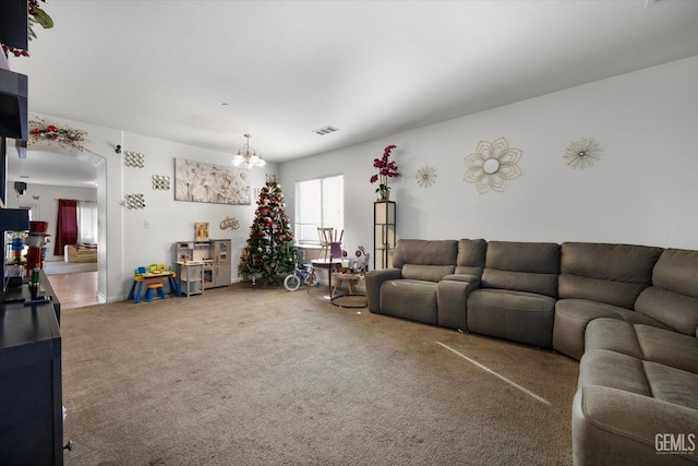 carpeted living room featuring a notable chandelier